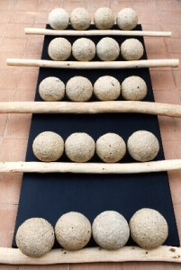 Installazione con palle di cartamacerata e legni di Ivano Vitali